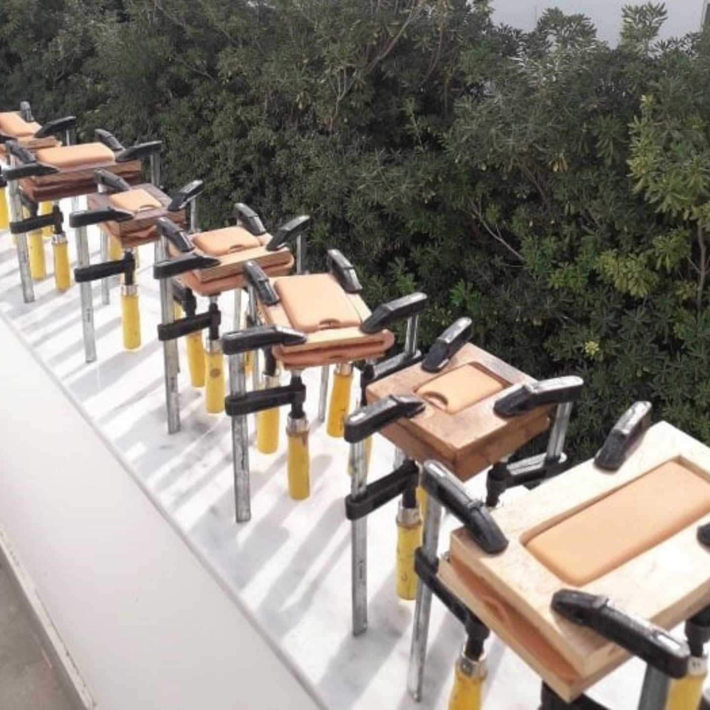 Wet-molded leather pouches drying on wooden molds outside EXODOS Copenhagen workshop