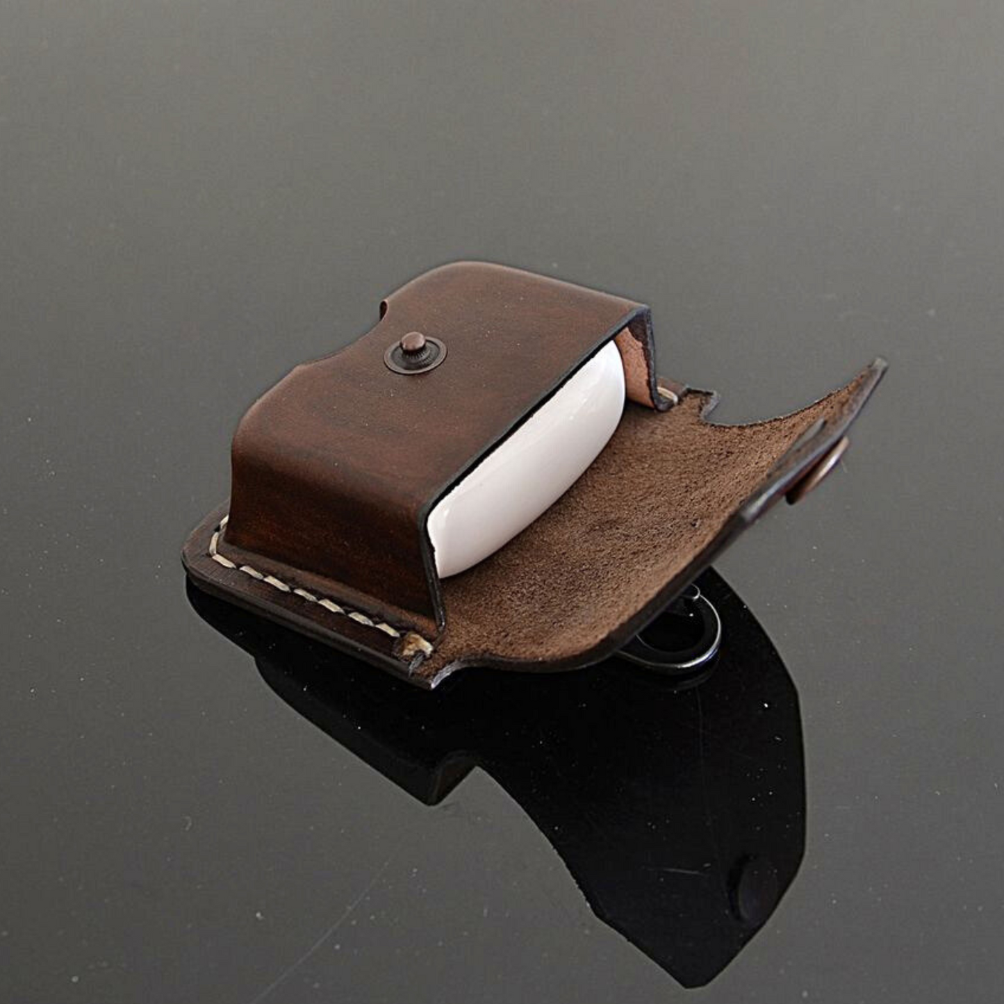 Side angle of brown leather earbuds pouch with belt clip and secure snap closure
