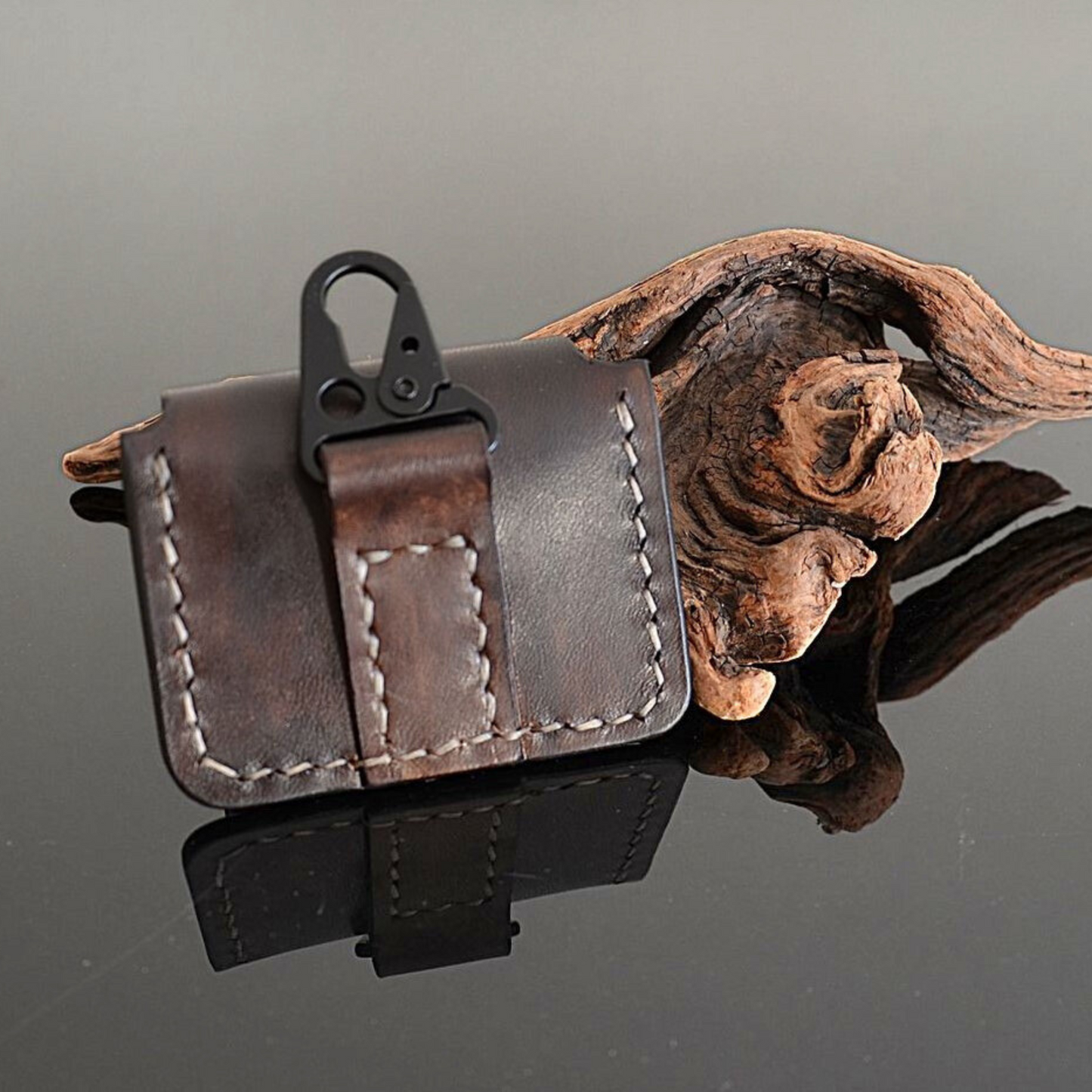Back side of hand stitched leather earbuds case with clip for lanyard